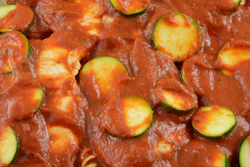 Close up of zucchini, chicken, pasta and tomato sauce casserole preparation