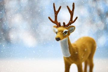 A Cute Young Reindeer in a Defocused Winter Landscape Background - obrazy, fototapety, plakaty