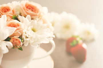 Delicate flower bouquet in cup on table