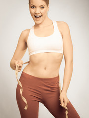 Obraz premium Time for diet weight loss. Fit girl with measure tape.