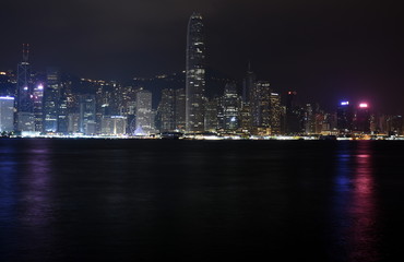 Fototapeta na wymiar Beautiful night view of Hong Kong island skyline across Victoria Harbour from Avenue of Stars at Kowloon. Skyscrapers on waterfront in downtown. Global financial center.