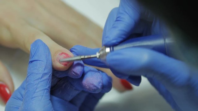 Manicurist removing the old gel polish