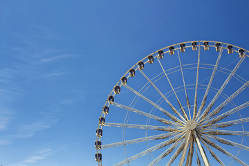 Half view of ferris wheel with blue sky background at Jardin Des Tuileries in Paris.
