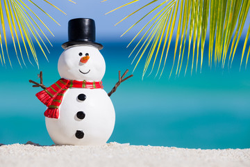 Snowman toy at white sandy beach