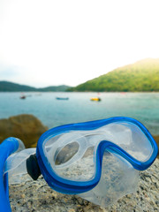 Snorkeling equipment: snorkel and diving google on the stone. Tr