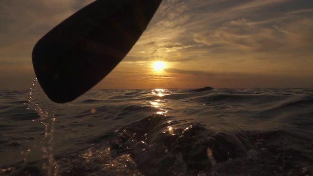 SLOW MOTION CLOSE UP: Detail of pushing paddle blade through glossy ocean water