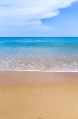 Fototapeta na wymiar white soft wave on empty tropical beach and blue sea with blue sky and white cloud background