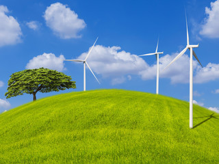 wind turbines generating electricity and tree on grass hill with blue sky .Ecology concept.