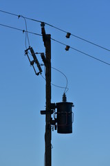 Silhouette of pole with electric wires and isolators.