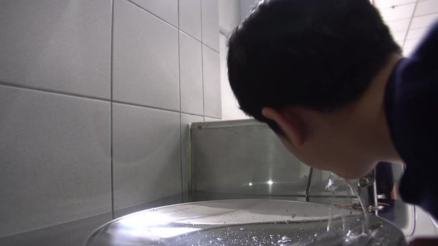 Asian hungry boy drinking water from water tube.