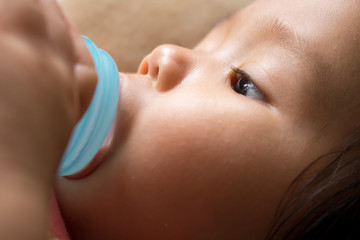 Baby girl is sucking milk from bottle before sleep.