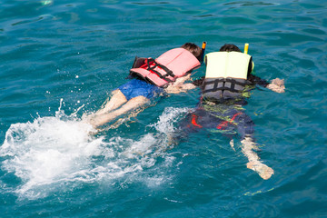 Man and women snorkeling in blue sea