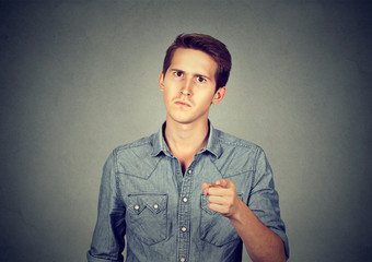 angry young man pointing finger at you camera