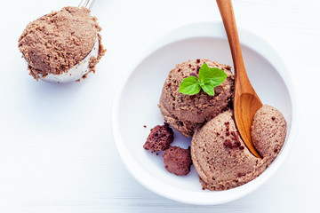 Close up chocolate ice cream in white bowl with fresh peppermint