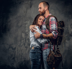 Urban backpackers couple on grey background.