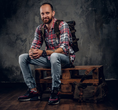 Bearded Tattooed Backpacker Posing In A Studio.