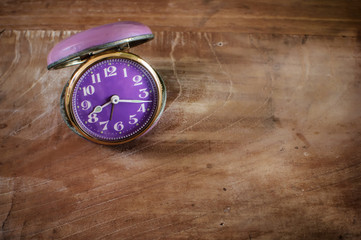 Retro alarm clock on wooden table, time concept and moment of truth idea