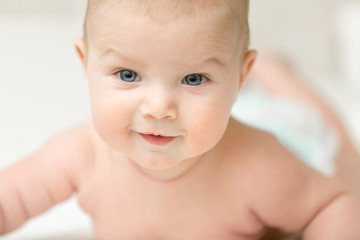 Portrait of an adorable smiling baby holds head up. Family concept photo, lifestyle, closeup