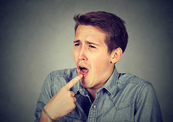 disgusted man with finger in mouth displeased ready to throw up