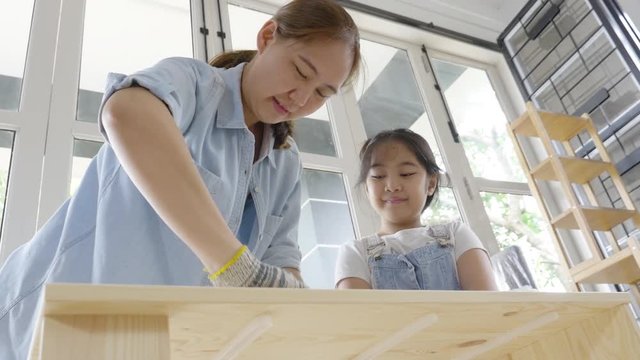 4K : Asian lovely girl helping her mother assembling new DIY furniture at home together