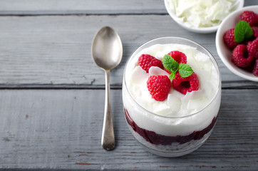Healthy breakfast, desert, with chia seed pudding, cream, raspberry jam, coconut flakes and fresh berries