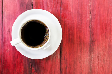 Coffee cup on red wood background