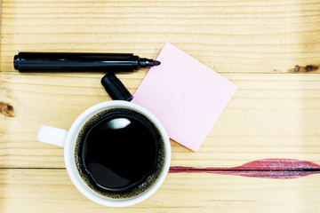 Empty pink pos it and laptop keyboard, on red wood background
