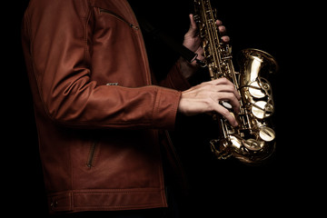 Obraz premium Jazz saxophone musician in the leather jacket, closeup.
