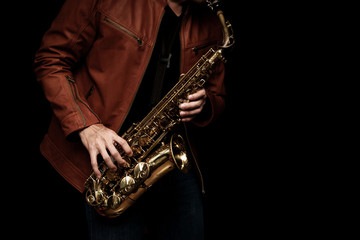 Jazz saxophone musician in the leather jacket, closeup.