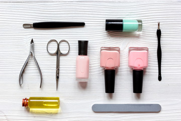 nail polish, cuticle oil and manicure set on wooden background
