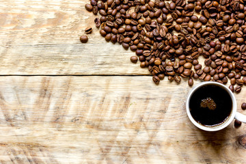 coffee beans on wooden with coffe cup table top view