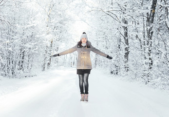 Happy girl walking in a beautiful winter forest