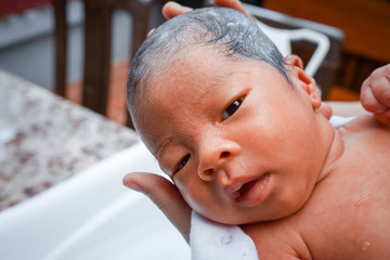 First bathing of a newborn baby boy in a  bathtub.