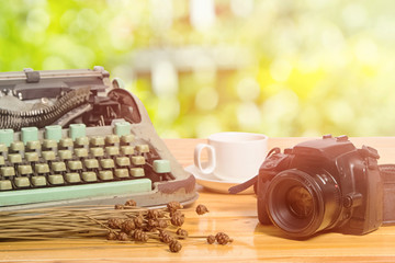 vintage typewriter and camera on green bright blur background