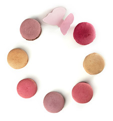Pastel colored macarons and paper butterfly frame on white