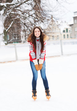 Young and pretty girl skating on an outdoor ice rink