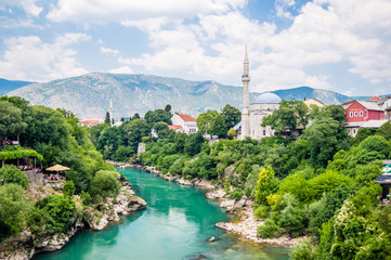Beautiful view on Mostar city with old bridge, mosque and ancient buildings on Neretva river in...