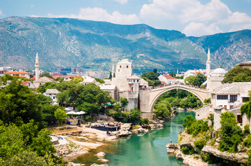 Fototapeta na wymiar Beautiful view on Mostar city with old bridge, mosque and ancient buildings on Neretva river in Bosnia and Herzegovina