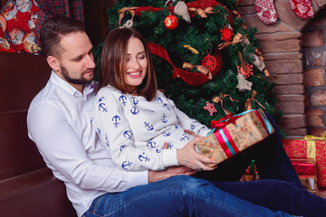 Young couple opening a Christmas present - 125795976