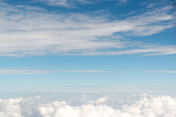 Cloudscape view above white clouds and blue sky from airplane