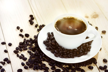 Coffee cup and coffee beans with steam on wooden table background, Close-up.