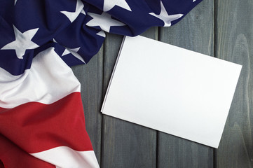 United States of America flag with empty space to write your text on sheet of paper on wooden background.