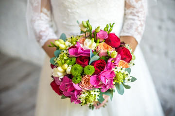 Bride holding rose pink wedding bouquet of roses and love flowers