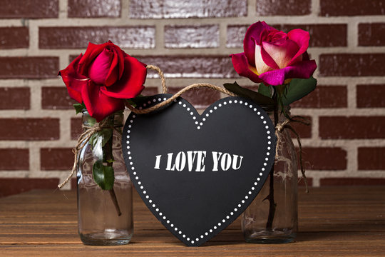 Rosas rojas con floreros de cristal y pizarra con I love you. Stock Photo |  Adobe Stock