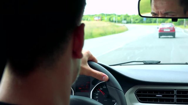 young handsome man drives a car on the road - closeup