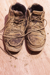 Dirty shoes with dried mud on the floor