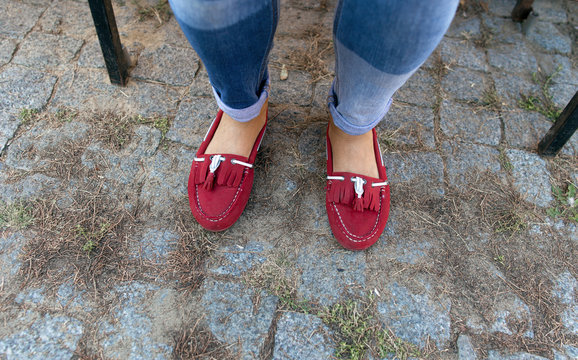 Womens legs in jeans and red loafers