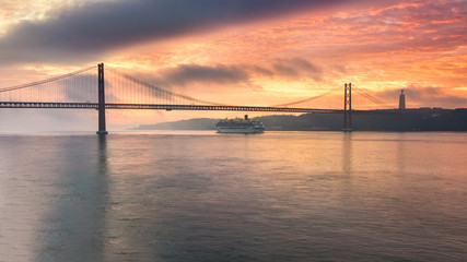 Fototapeta na wymiar Lisbon at dawn, cruise past the bridge at sunrise.
