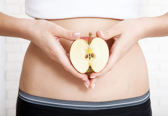 Pregnancy or diet concept, female hands holding apple. Concept of natural food