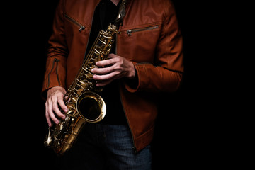 Fototapeta na wymiar Jazz saxophone musician in the leather jacket, closeup.